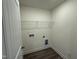 Functional laundry room featuring a wire shelf and convenient hookups for appliances at 129 Stallion Way, Benson, NC 27504