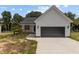 Newly built home with white siding, a black garage door and a small front porch at 131 Tanglewood Dr # 10-J, Louisburg, NC 27549