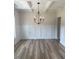 Dining room features hardwood floors, wainscoting and modern black chandelier at 145 Surles Landing Way, Benson, NC 27504