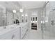 Modern bathroom with white double vanities, a large mirror, and a glass shower at 2105 Dunhill Dr, Raleigh, NC 27608