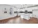 Modern kitchen with white cabinets, island, and dark tile backsplash at 602 Hillfarm Dr, Wake Forest, NC 27587