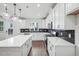 Open concept kitchen with modern white cabinets, large island, stainless steel appliances and pendant lighting at 602 Hillfarm Dr, Wake Forest, NC 27587