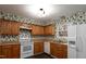 Kitchen with wood cabinets and white appliances at 6409 New Market Way, Raleigh, NC 27615