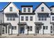 Three-story townhouses featuring white siding, blue doors, and black accents at 8610 Brushfoot Way # 106, Raleigh, NC 27616