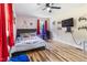 Bright bedroom with wood floors, a baseball-themed bed, and red curtains at 889 Burlington Rd, Roxboro, NC 27573