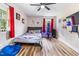 Bright bedroom with wood floors, a baseball-themed bed, and red curtains at 889 Burlington Rd, Roxboro, NC 27573