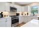 Modern kitchen features stainless steel appliances and white cabinetry at 889 Burlington Rd, Roxboro, NC 27573