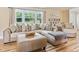 Living room with sectional sofa, ottoman, and large windows at 889 Burlington Rd, Roxboro, NC 27573