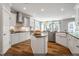 A kitchen with white cabinets, stainless appliances, an island, and wood floors at 9349 Kitchin Farms Way # 463, Wake Forest, NC 27587