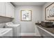 Functional laundry room with modern washer and dryer, art, and counter space at 9349 Kitchin Farms Way # 463, Wake Forest, NC 27587