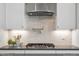 A kitchen with a stovetop, stainless vent, and white subway tile at 9349 Kitchin Farms Way # 463, Wake Forest, NC 27587