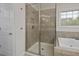 Bathroom featuring tiled shower with glass door and soaking tub at 108 Cross Oaks Pl, Holly Springs, NC 27540