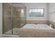 Beautiful bathroom with a large soaking tub and glass-enclosed shower stall at 108 Cross Oaks Pl, Holly Springs, NC 27540