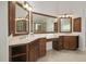 Bathroom showcasing dual sinks with dark wood cabinetry, large mirrors and tiled floor at 108 Cross Oaks Pl, Holly Springs, NC 27540