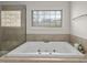 Bathroom with soaking tub under window and tiled shower with glass door at 108 Cross Oaks Pl, Holly Springs, NC 27540