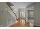 Bright foyer with hardwood floors, staircase, and view into the living spaces at 108 Cross Oaks Pl, Holly Springs, NC 27540