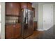 Close-up of stainless steel refrigerator and beautiful cherry wood cabinets in kitchen at 108 Cross Oaks Pl, Holly Springs, NC 27540