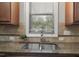 Kitchen sink with a granite countertop and window providing natural light at 108 Cross Oaks Pl, Holly Springs, NC 27540