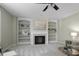 Bright living room with fireplace, built-in shelves, and ceiling fan at 108 Cross Oaks Pl, Holly Springs, NC 27540