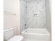 Bathroom with a shower/tub combo and marble-look tile at 1127 Elmo St, Durham, NC 27701