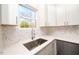 White kitchen cabinets, marble backsplash, and stainless steel sink at 1127 Elmo St, Durham, NC 27701