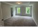 Spacious bedroom featuring a tray ceiling, plush carpeting, and ample natural light at 137 Stallion Way, Benson, NC 27504