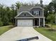 Charming two-story home boasts stone accents, a two-car garage, and a welcoming front yard at 137 Stallion Way, Benson, NC 27504
