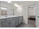 Double vanity bathroom with gray cabinets and bedroom access at 148 Cumberland Dr, Sanford, NC 27332