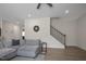 Open living room with gray sectional and staircase at 148 Cumberland Dr, Sanford, NC 27332