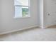 A brightly lit bedroom with a window view and access to a hallway door, ready for personalization at 155 Scenic Rock Dr, Youngsville, NC 27596