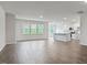 Open-concept living area with hardwood floors, bright windows, and a view into the modern kitchen at 155 Scenic Rock Dr, Youngsville, NC 27596
