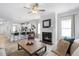 Open living room with a fireplace, kitchen views, and plenty of natural light at 168 Northwood Dr, Fuquay Varina, NC 27526