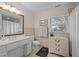 Clean bathroom with white vanity, neutral tile, and a large mirror at 1991 Webster Grove Dr, Mebane, NC 27302