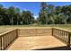 A wooden back deck overlooks a large wooded area and backyard at 286 Longbow Dr, Middlesex, NC 27557