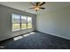 Sunlit bedroom with plush carpet, a ceiling fan, and a large window offering a pleasant view of the neighborhood at 286 Longbow Dr, Middlesex, NC 27557