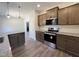 Modern kitchen with dark cabinets, granite countertops, and stainless steel appliances, complete with stylish flooring at 286 Longbow Dr, Middlesex, NC 27557