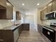 Well-equipped kitchen featuring stainless steel appliances, granite countertops, and dark wood cabinets, with stylish wood floors at 286 Longbow Dr, Middlesex, NC 27557