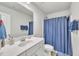 Bright bathroom with a single sink vanity and a shower with a blue curtain at 298 Hannah Yam Ln, Benson, NC 27504