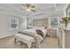 Primary bedroom features a decorative tray ceiling, bench, and natural light from two windows at 298 Hannah Yam Ln, Benson, NC 27504