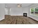 Spacious living room with a fireplace, ceiling fan, and large windows overlooking the yard at 298 Hannah Yam Ln, Benson, NC 27504