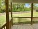 Covered patio with wood flooring looking out into a large grassy backyard with a wood fence at 298 Hannah Yam Ln, Benson, NC 27504