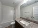 Well-lit bathroom with a vanity, granite countertops, a shower-tub combo, and modern fixtures at 302 Longbow Dr, Middlesex, NC 27557