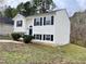 Side view of a white two-story house with black windows and landscaping at 311 Gladstone Dr, Durham, NC 27703