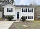 Two-story white house with black windows, landscaping, and a driveway at 311 Gladstone Dr, Durham, NC 27703