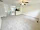 Open living room with neutral carpeting, and a view of the kitchen and staircase at 311 Gladstone Dr, Durham, NC 27703