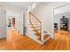 Elegant staircase with glass and wood accents, hardwood floors, and access to other rooms at 1 Pointe View Ct, Durham, NC 27713