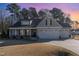 Gray two-story house with a three-car garage and covered porch at 102 Mallory Ct, Clayton, NC 27520