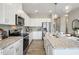 Well-lit kitchen featuring white cabinets, granite countertops, stainless steel appliances, and wood flooring at 103 Siebold St, Garner, NC 27529