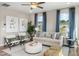 Bright living room featuring stylish seating, large windows with blue curtains, and contemporary decor at 103 Siebold St, Garner, NC 27529