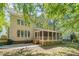 Back exterior of a two-story home featuring a screened-in porch and large yard at 106 Dairy Ct, Chapel Hill, NC 27516